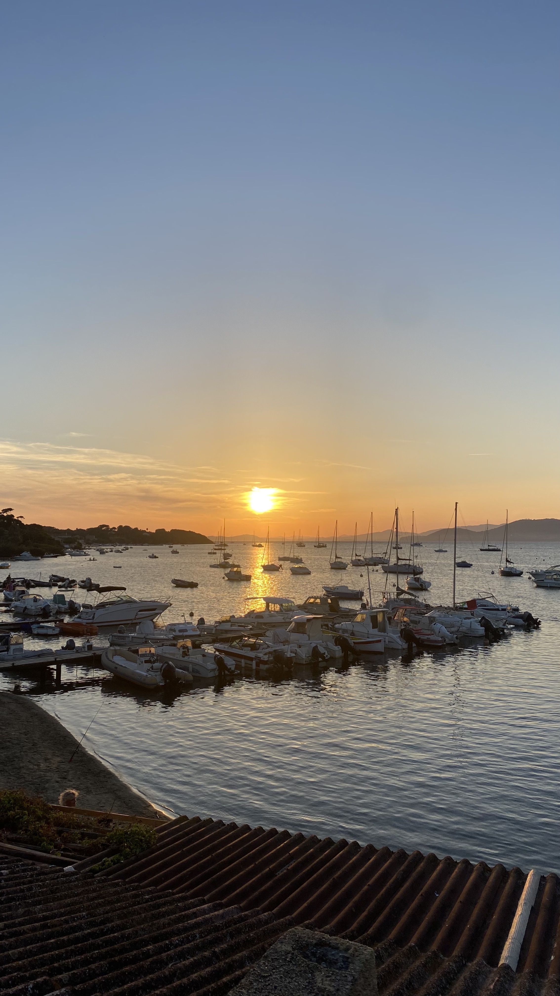 Petits bateaux dans une baie de la presqu’île de Giens au coucher du soleil