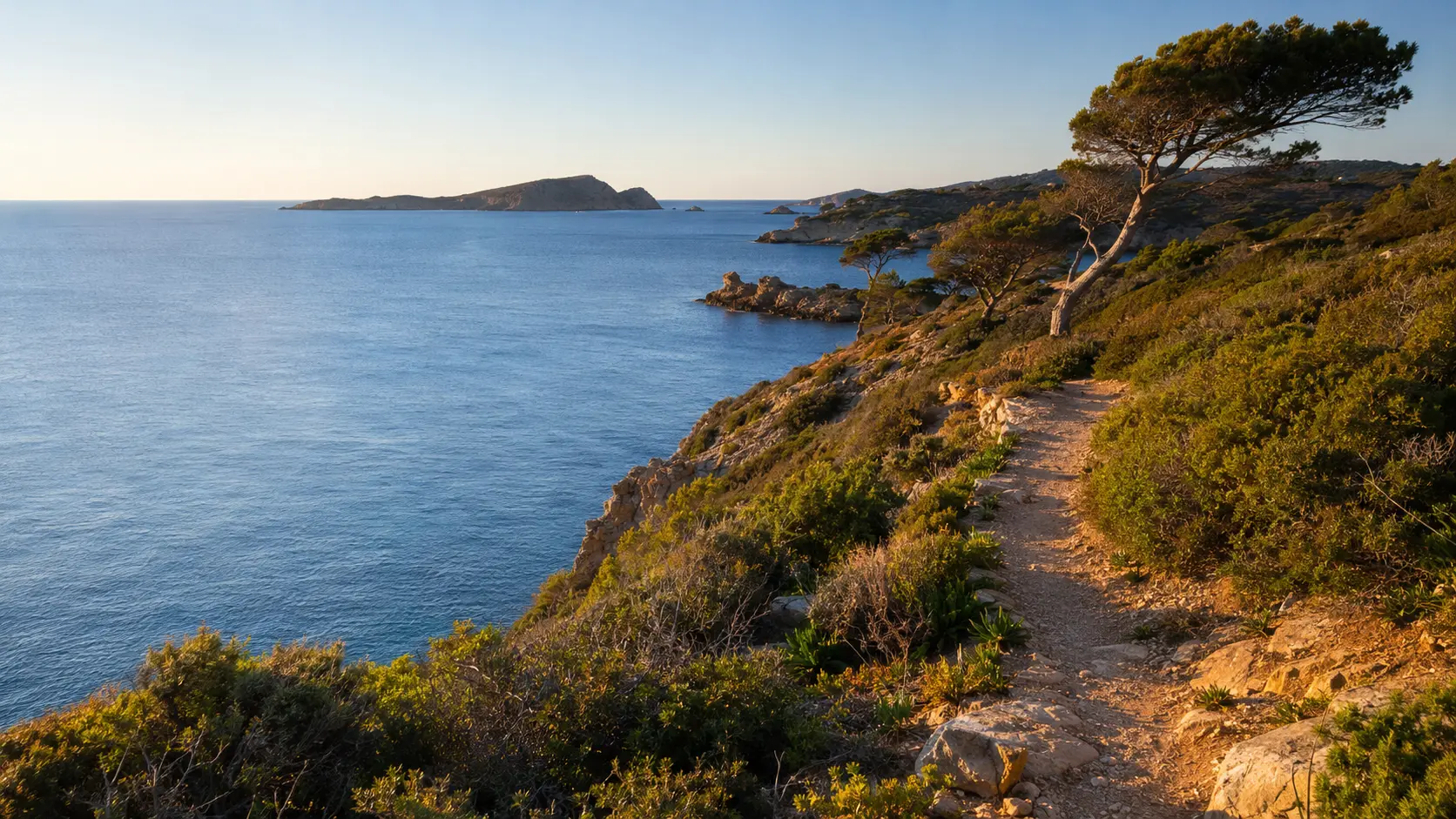 Sentier côtier rocheux dominant la Méditerranée au soleil levant