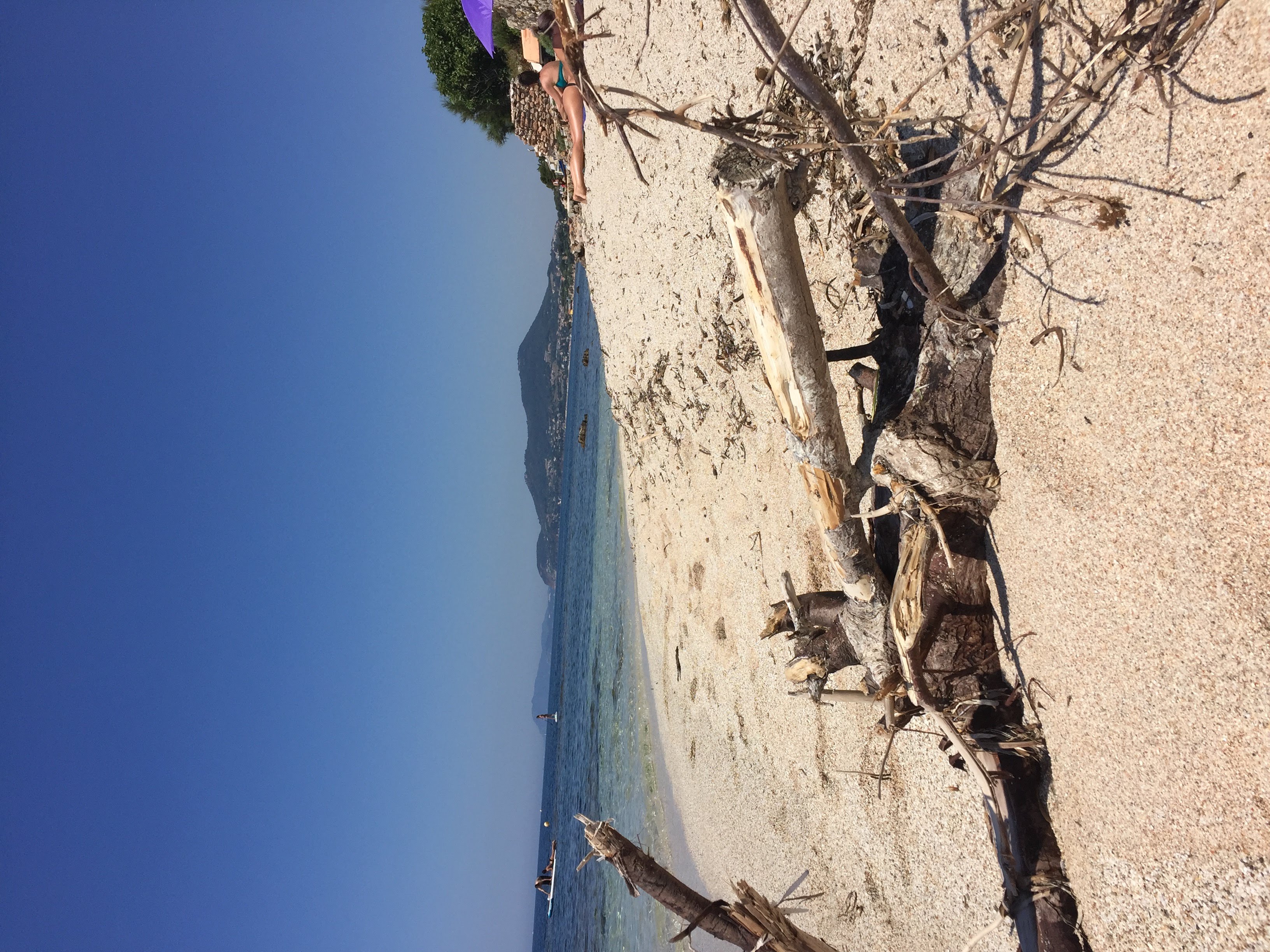Plage de sable sur le littoral de Hyères, avec mer et collines au loin